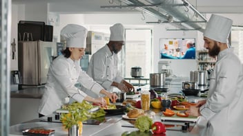 grupo de chefs preparan diversos platillos para el servicio de comedor de una empresa