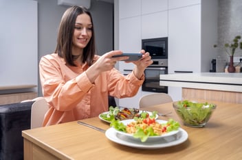 empleada feliz toma una foto a sus alimentos saludables en el comedor industrial de su empresa