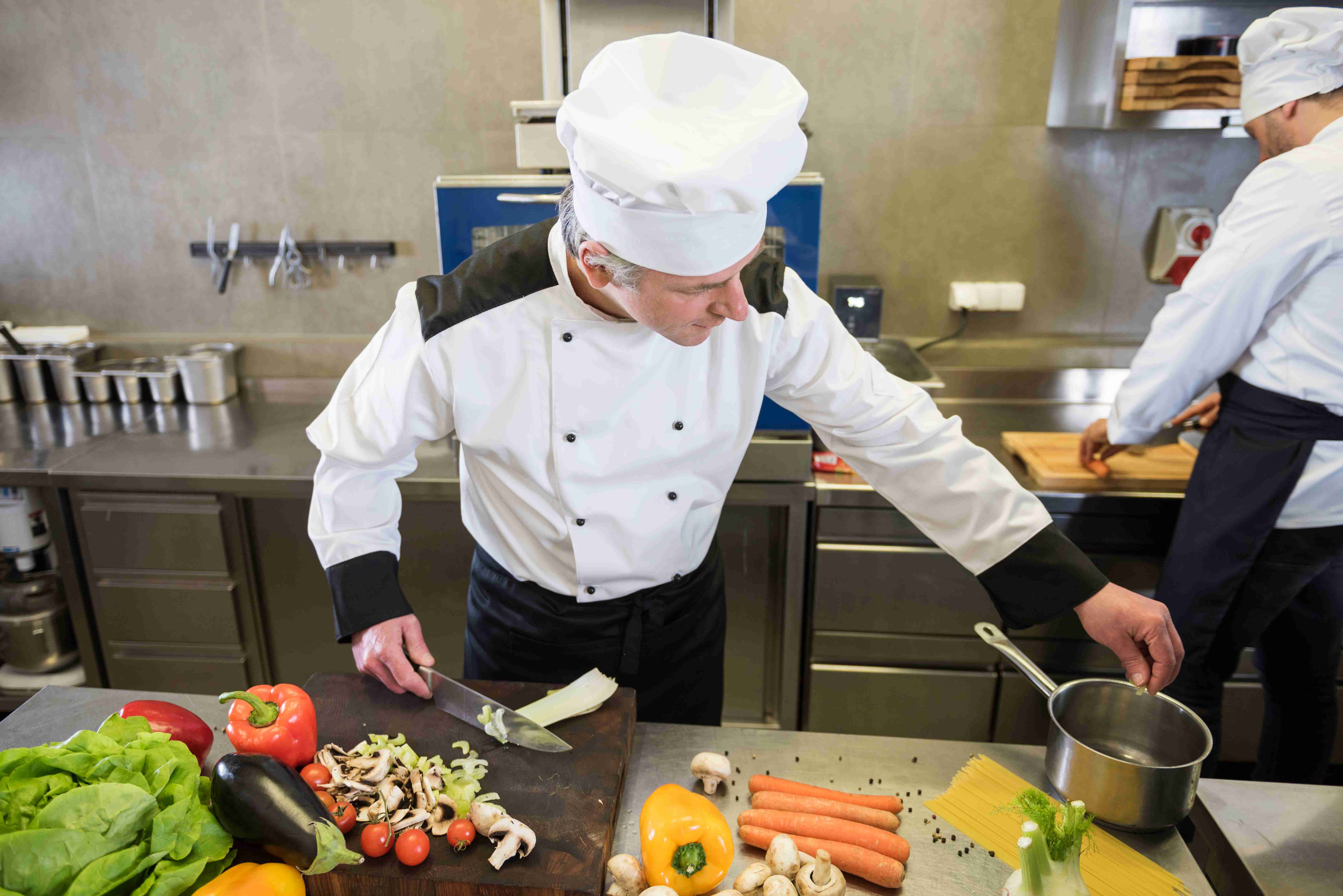 chef preparando varios alimentos de forma segura en un comedor industrial certificado 