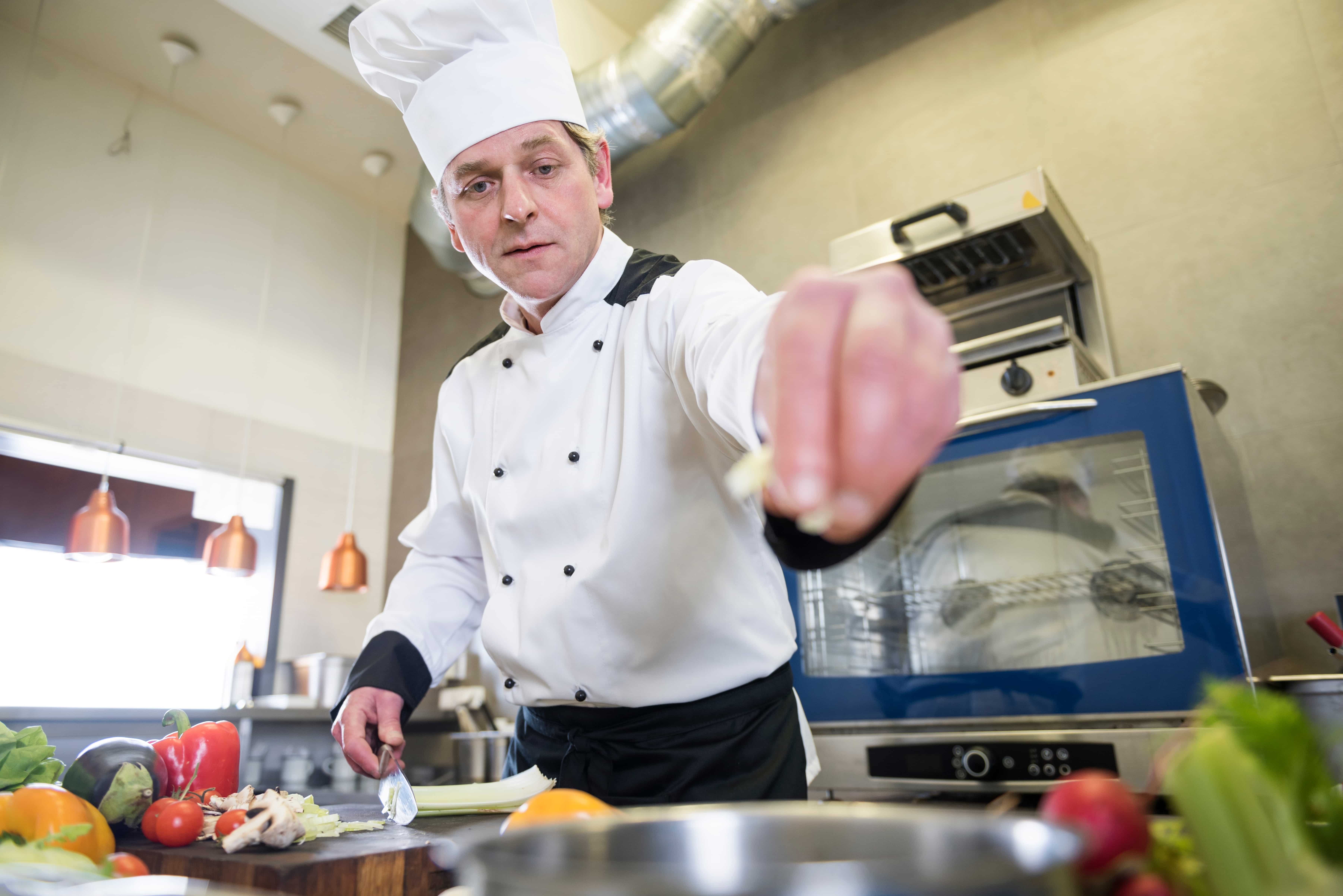 chef verifica la calidad de los alimentos en un comedor industrial 