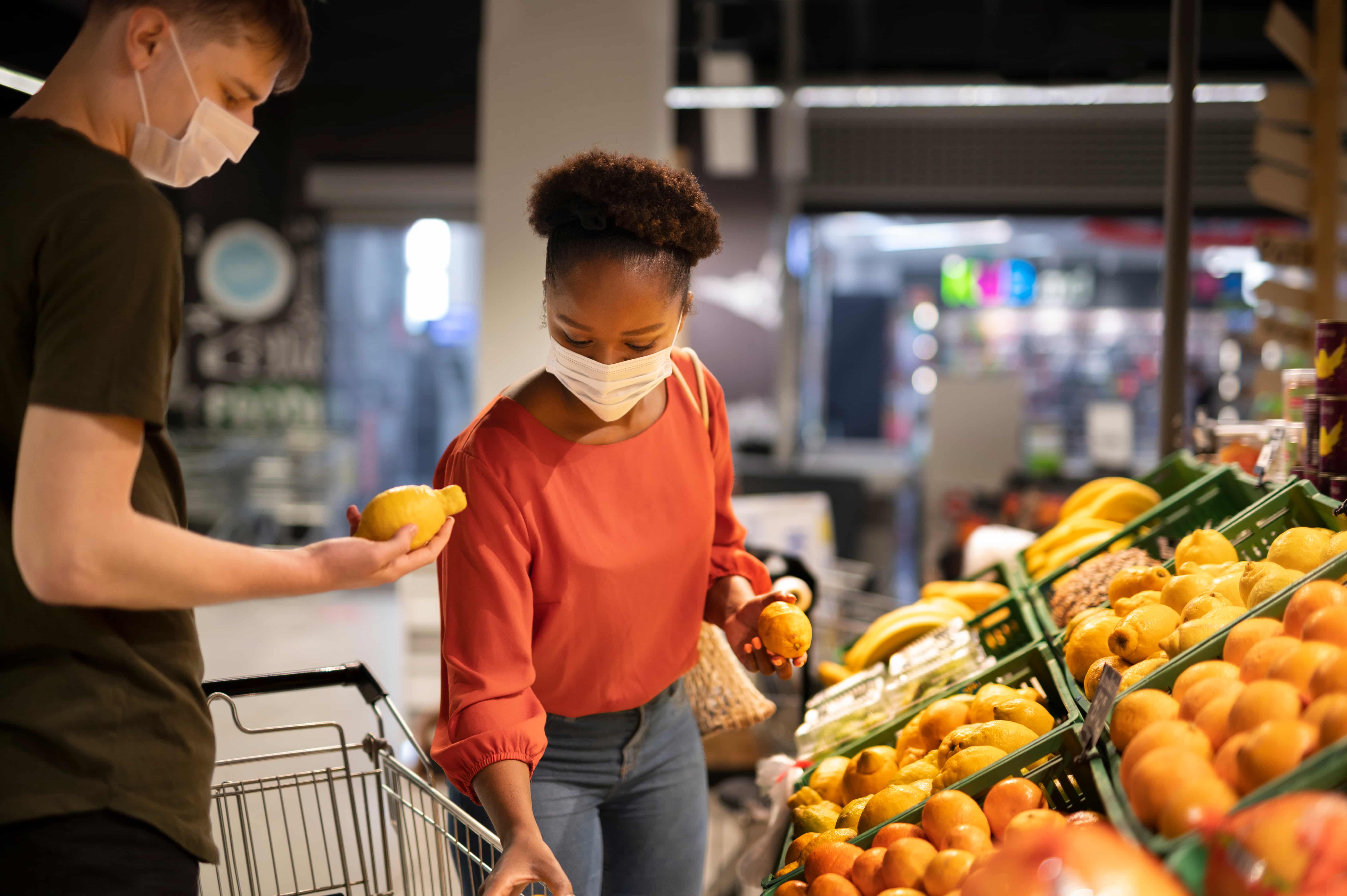personas con cubrebocas compran alimentos saludables en tiempos de pandemia 